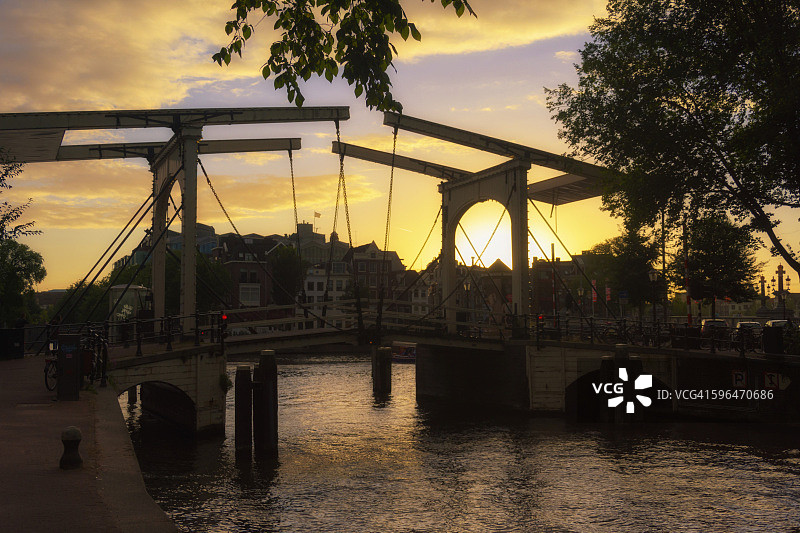荷兰。黄昏时分阿姆斯特丹城市运河的一座桥的剪影。图片素材