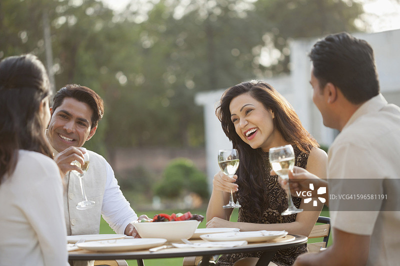 印度，朋友们在后院的餐桌上喝酒图片素材