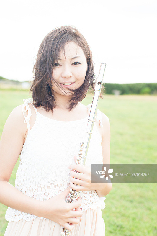 在田野里演奏长笛的女人图片素材