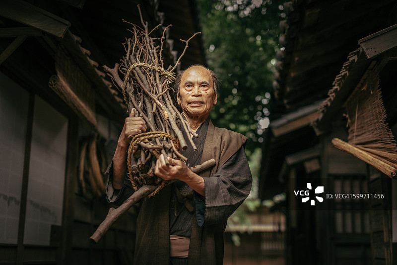 穿着传统服装，背着柴火的日本人图片素材