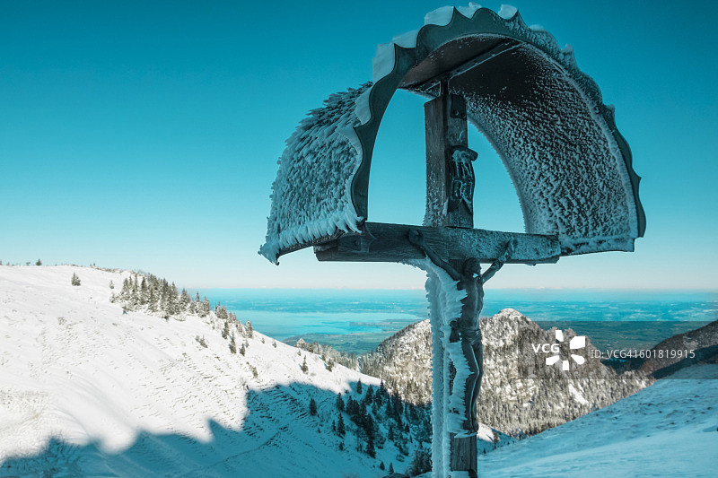 德国，巴伐利亚州，基姆高，坎彭旺德，冬季基姆湖上空的十字架图片素材