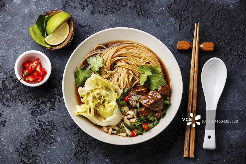 辣的亚洲面条肉汤与牛肉在深色背景图片素材