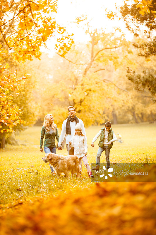一家人在秋季公园和他们的狗图片素材