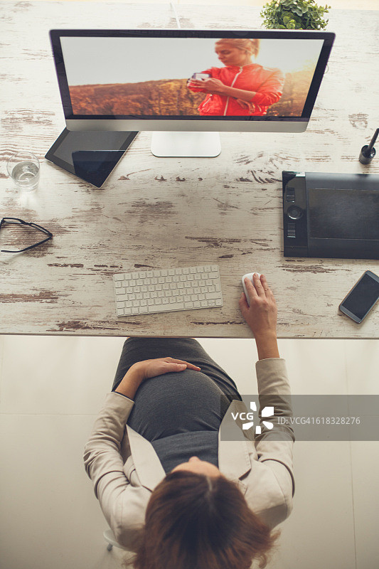 孕妇在电脑上工作的俯视图图片素材