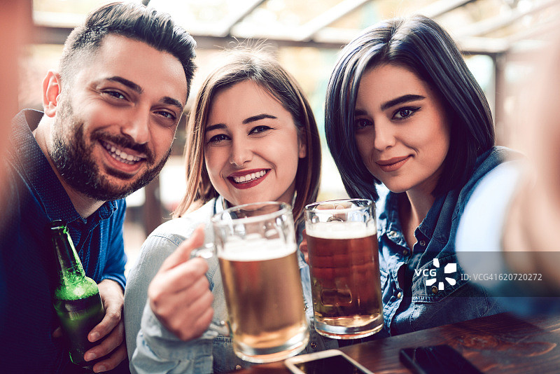 一群朋友在酒吧喝啤酒、自拍图片素材
