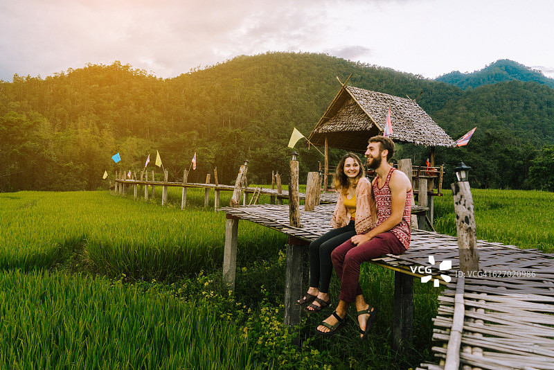 一对夫妇在稻田附近的竹桥上图片素材