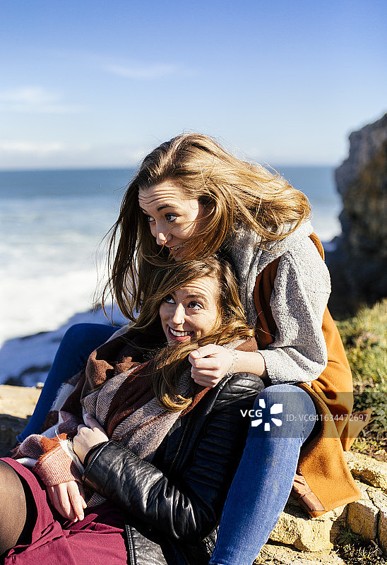 西班牙，希洪，两个年轻女人在海边玩图片素材