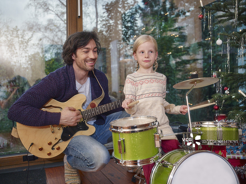 父亲和女儿在圣诞夜演奏音乐图片素材