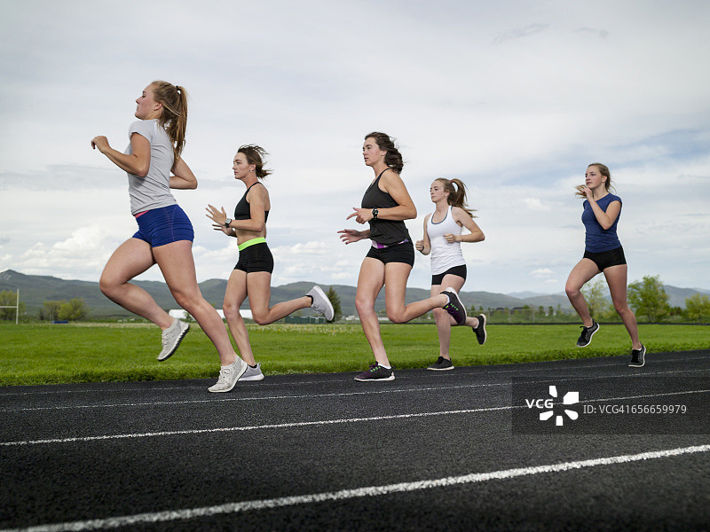 年轻女子在学校跑道上跑步图片素材