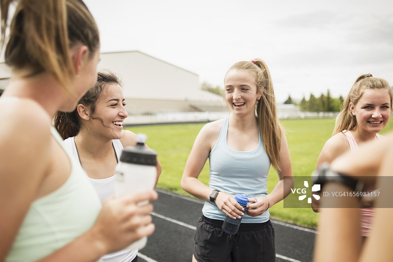 年轻的女运动员在学校的跑道上欢笑图片素材