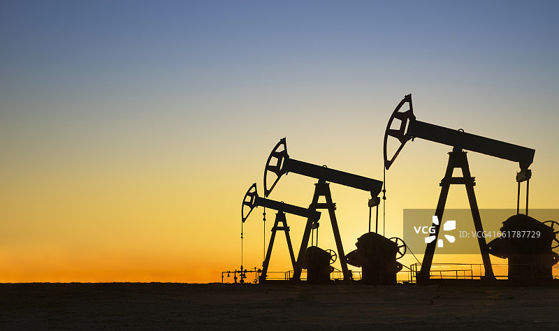 日落时分，美国德克萨斯州沙漠中油井的剪影图片素材