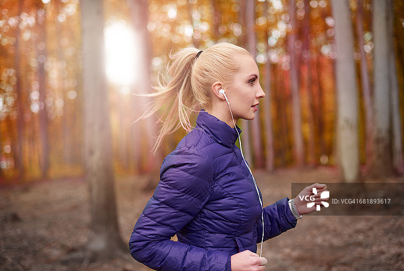 一个女人专注于在树林里跑步。Debica、波兰图片素材