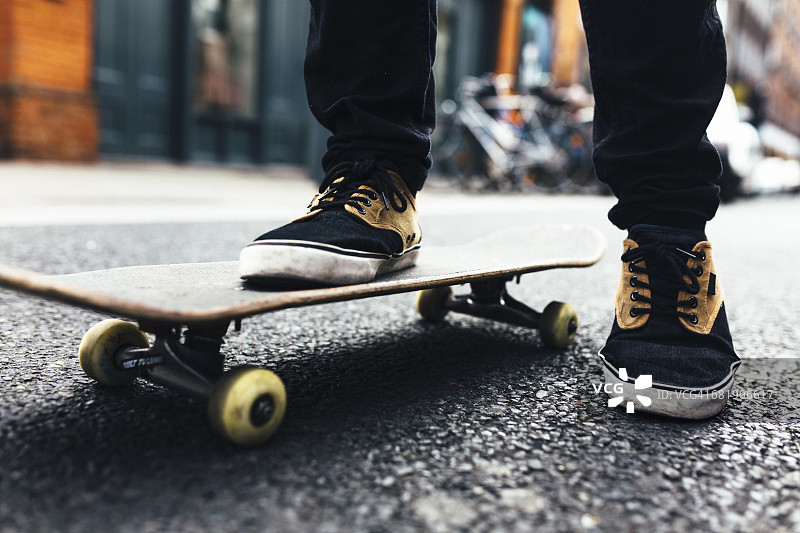 年轻的滑板手在街上，局部的视野图片素材