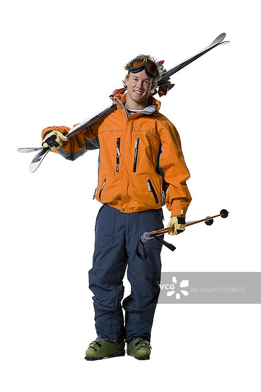一个年轻人拿着滑雪板和滑雪杖的肖像图片素材