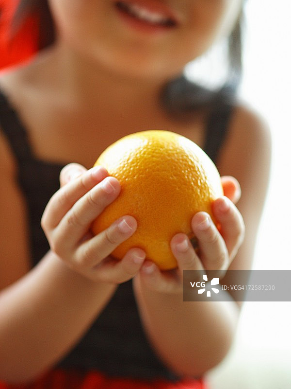 一个拿着橘子的女孩的特写图片素材