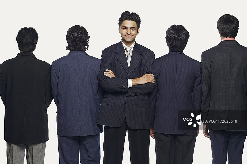 一个商人和他的四个同事站在相反的方向图片素材