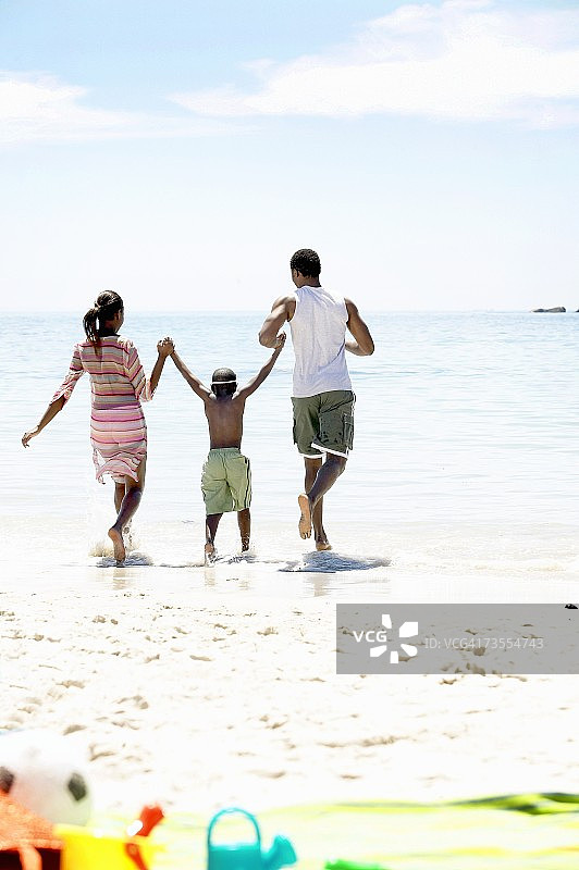 海滩上的非洲家庭，走向海洋图片素材
