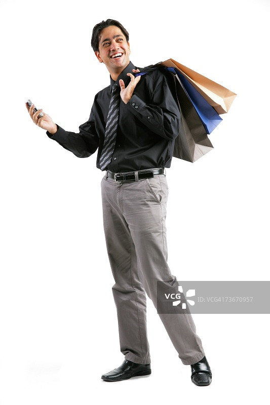 商人肩扛购物袋，手拿手机图片素材