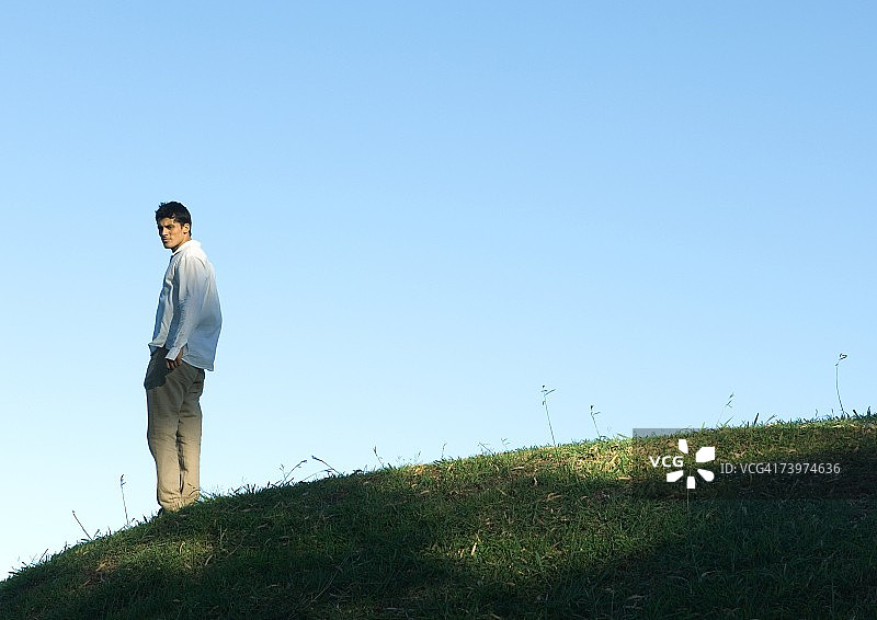一个人站在山上，从肩膀上看向镜头图片素材
