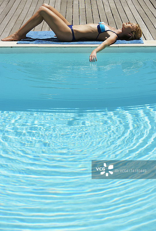 女人日光浴甲板与游泳池图片素材