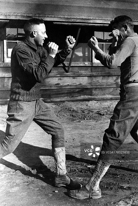 两个年轻的军人在军营外面打拳击。图片素材