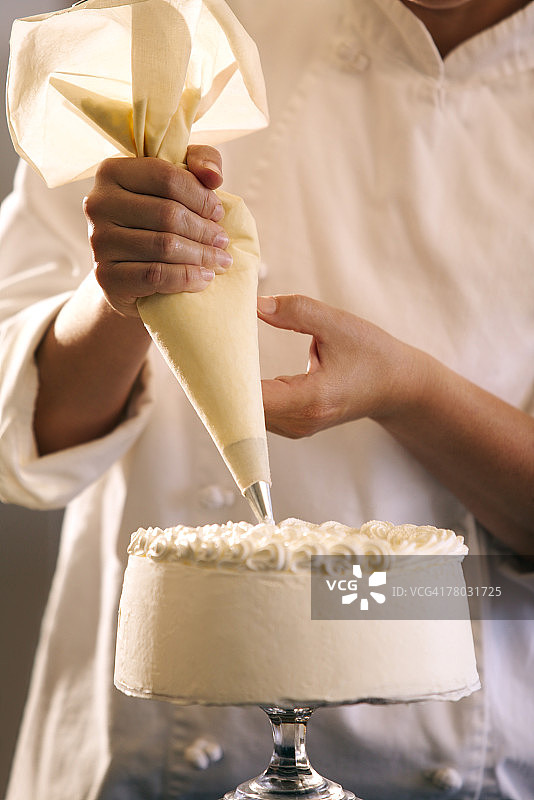 一个糕点厨师装饰蛋糕的特写图片素材