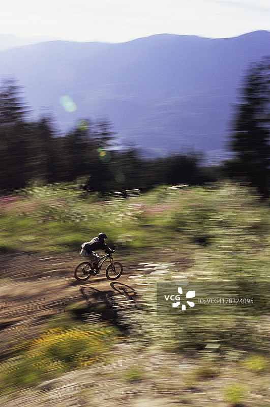 山地自行车手在崎岖的地形上骑行图片素材