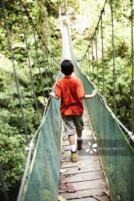 在荒野地区的桥上行走的男孩图片素材