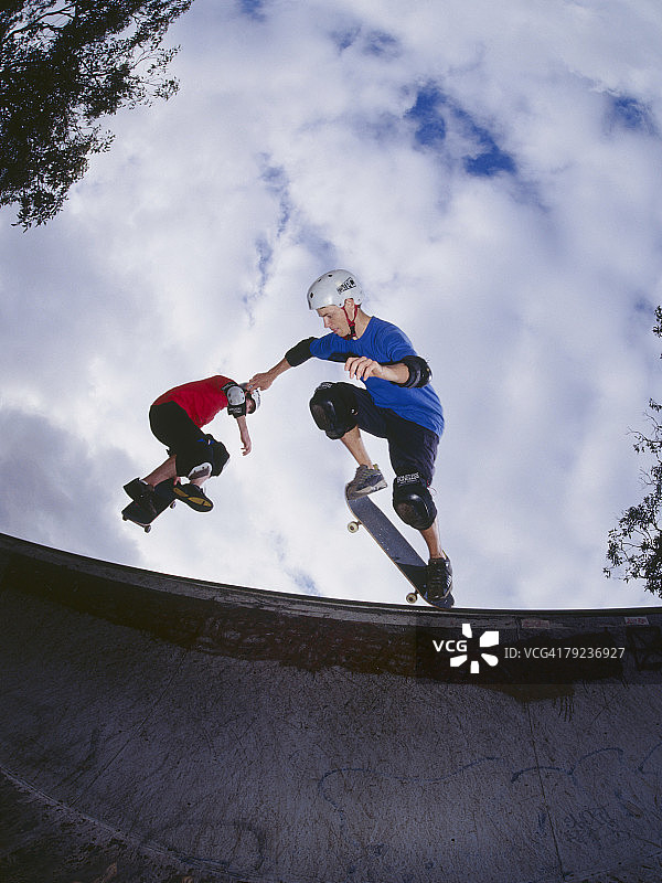 两个年轻人在斜坡上玩滑板图片素材