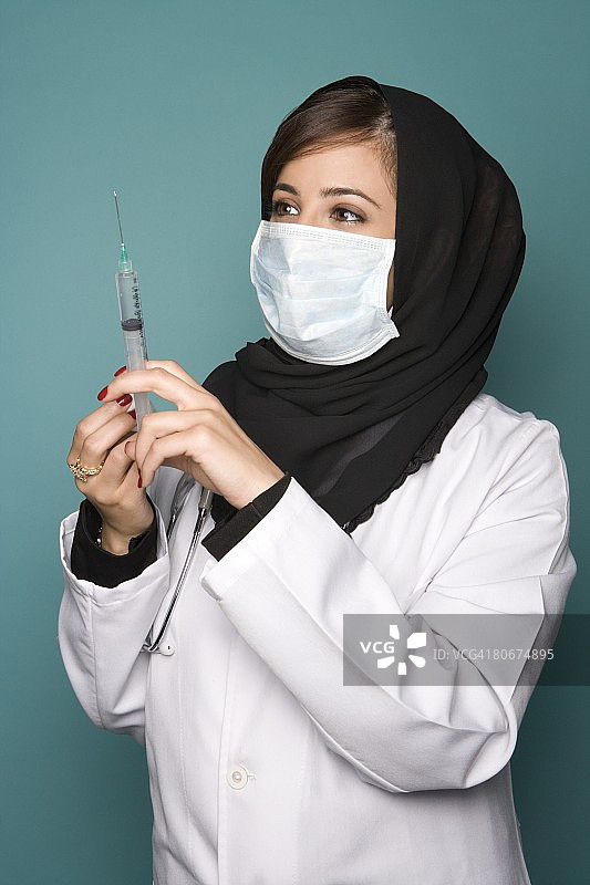 女医生带着外科口罩和注射器图片素材