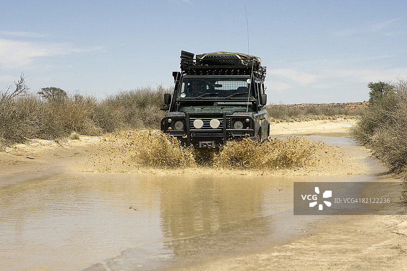 4 × 4驾驶通过水，卡拉加迪越境公园，南非图片素材