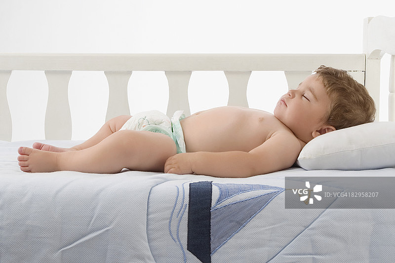 小男孩睡在婴儿床里图片素材