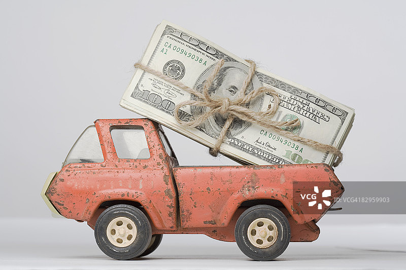一个玩具卡车装载一捆纸币的特写图片素材
