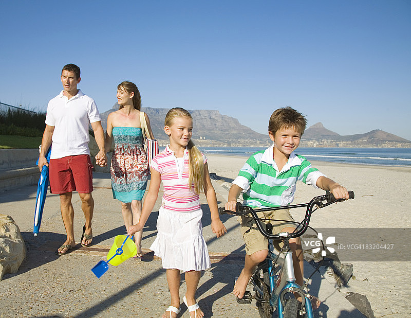 一家人在以桌山为背景的海滩上散步，开普敦，西开普省，南非图片素材