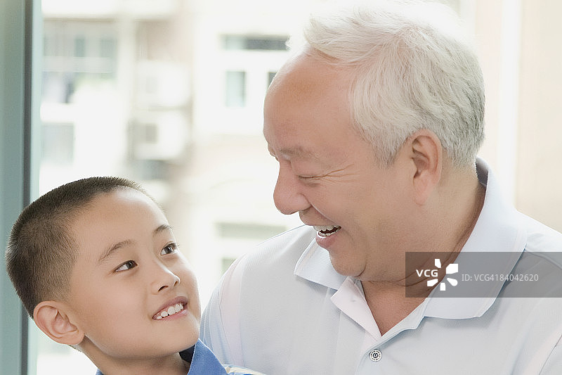 一个男孩和他的祖父微笑的特写图片素材