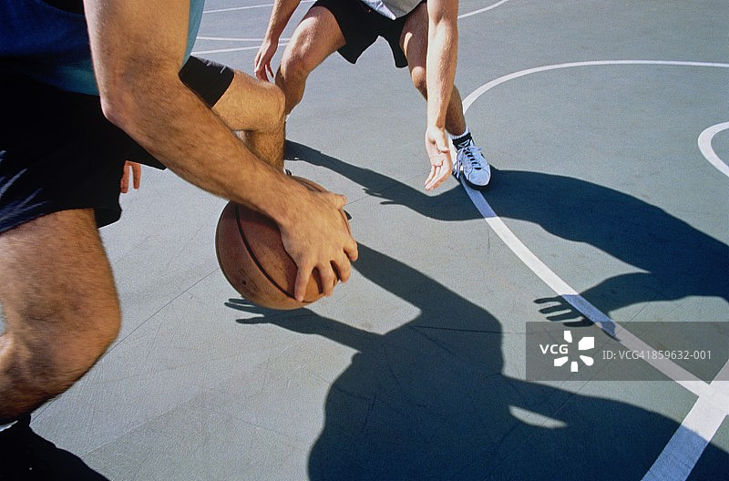 篮球，两个人一对一打，球场上阴影的特写图片素材