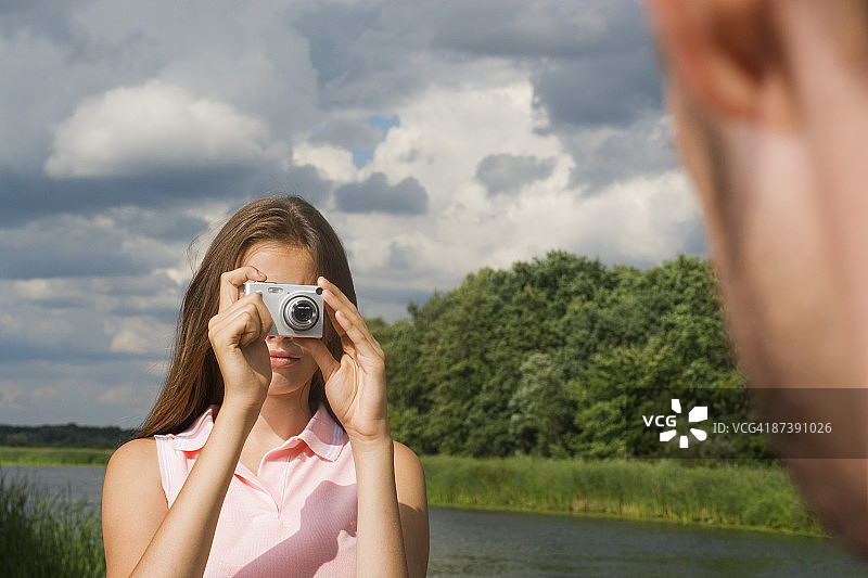 十几岁的女孩用数码相机给男友拍照图片素材