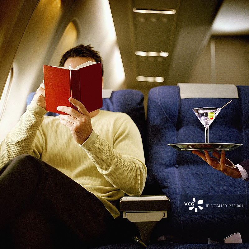 在飞机头等舱看书，喝马提尼图片素材