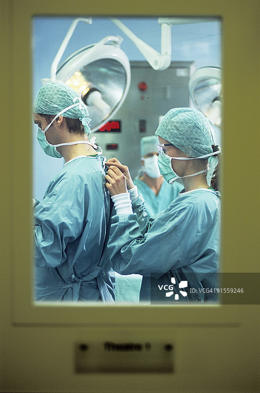 外科医生准备手术，护士协助外科医生穿衣图片素材