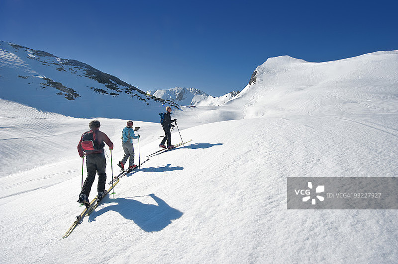 奥地利，萨尔茨堡，阿尔滕马克，索琛湖，三个人越野滑雪在山上，后视图图片素材