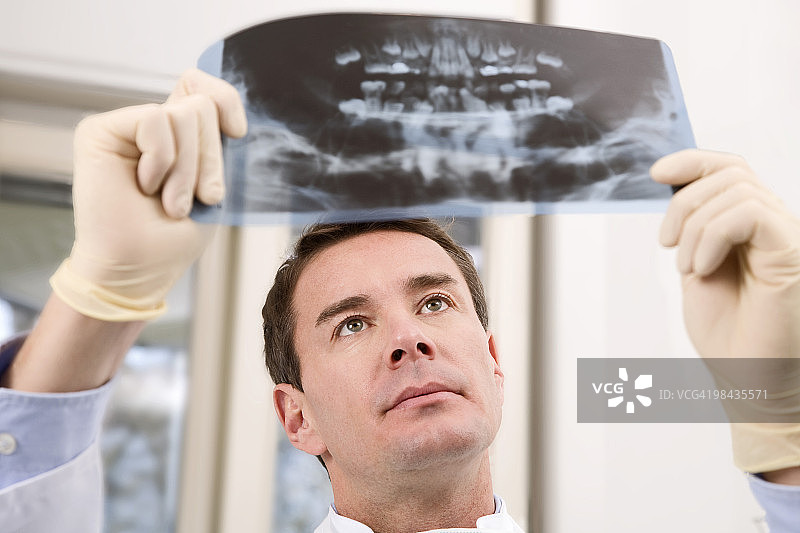 牙医看着病人的x光照片图片素材