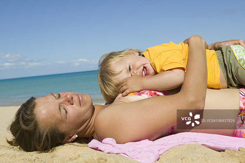 母亲和小儿子在沙滩上休息图片素材