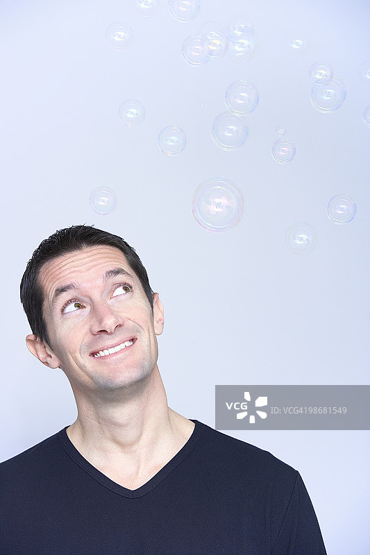 微笑的男人看着泡沫图片素材