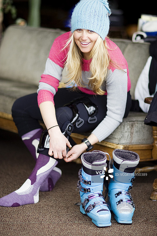 女性滑雪者调整膝盖支撑的肖像。图片素材