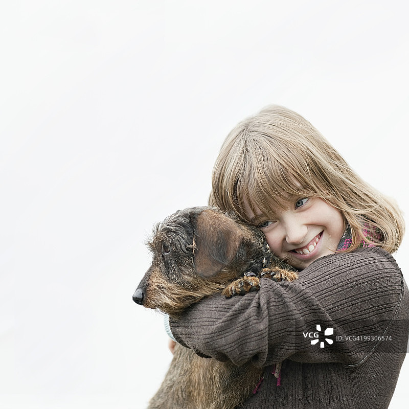 女孩抱在怀里的狗的肖像图片素材