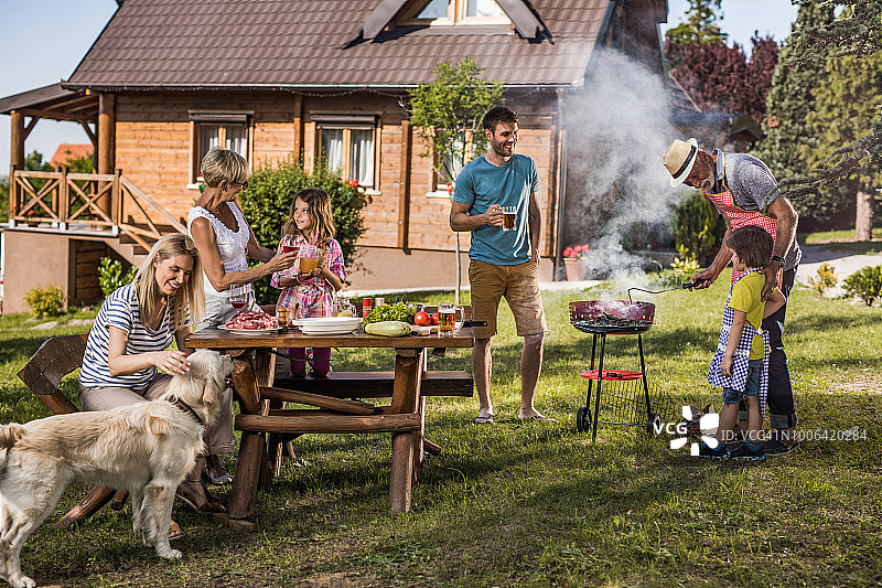 快乐的大家庭在后院享受烧烤派对。图片素材