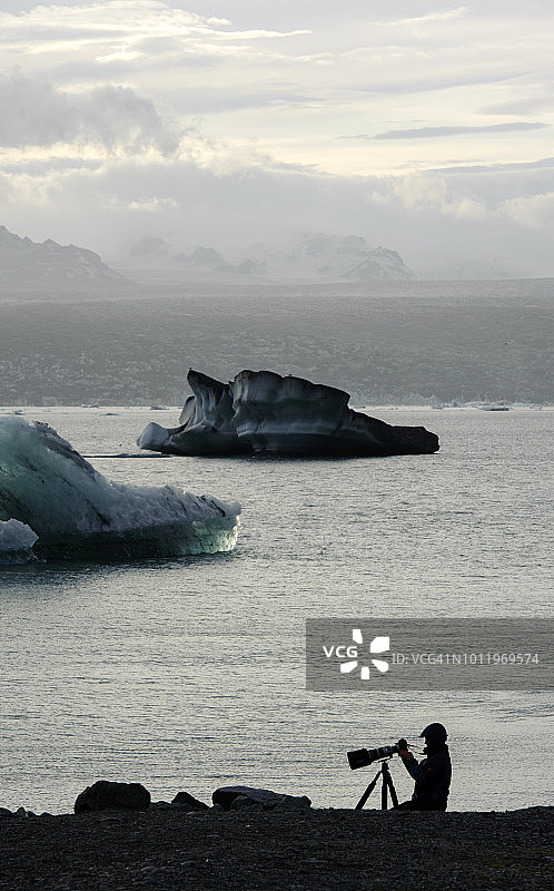 一名游客在冰岛东部Jökulsárlón泻湖拍摄照片图片素材