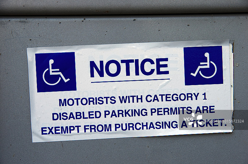 停车收费表上的标签:“注意:持有第一类伤残人士停车许可证的驾驶者可获豁免购票”图片素材
