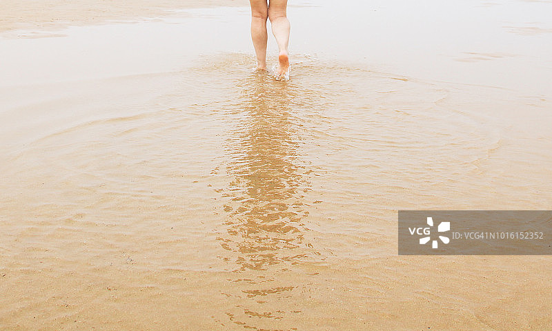 女人的腿在海滩上行走图片素材