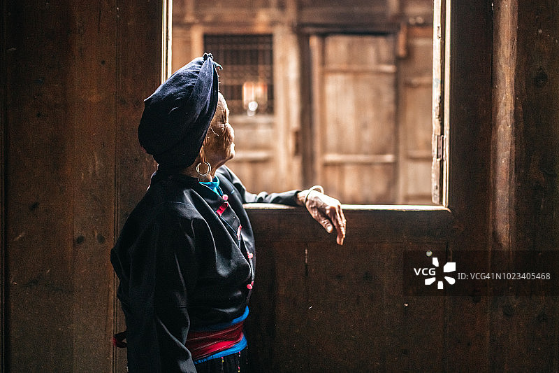 年迈的少数民族中国妇女望着窗外图片素材